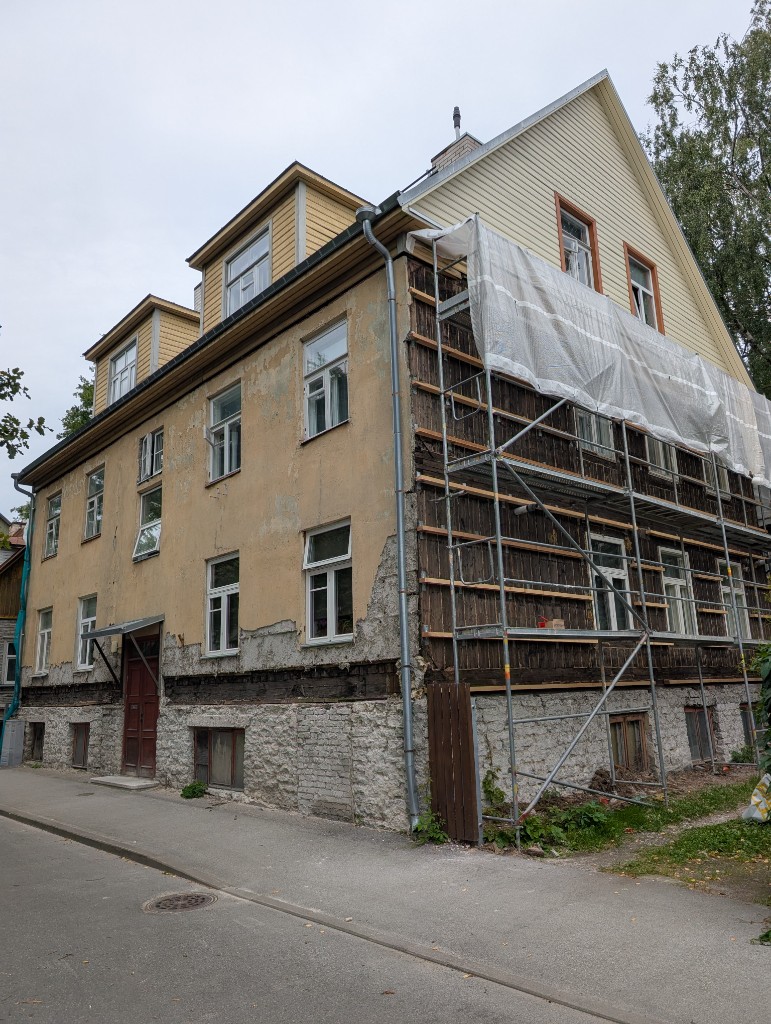 House facade with scaffolding on the renovated side